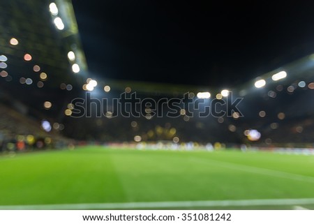 Blurred field with lights and full of spectators at the stadium one step at a sporting event