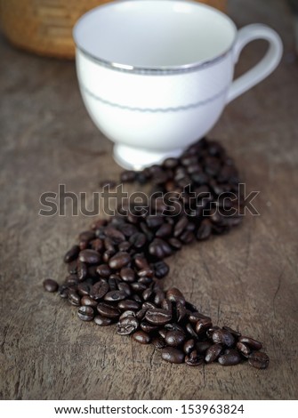Coffee cup and coffee bean on a wooden table