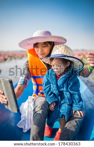 Mother and baby are playing tablets and a boat ride at Lake Lotus Red Sea