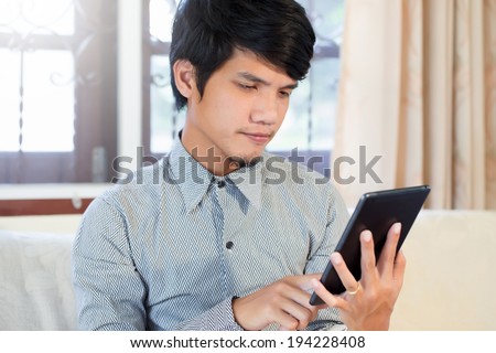 Serious young male executive using digital tablet