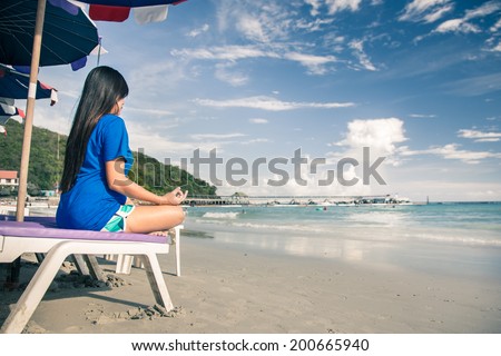 Meditation - Meditation girl yoga on the beach at dawn. Woman relaxing in lotus pose in the Zen calm sea during holidays.