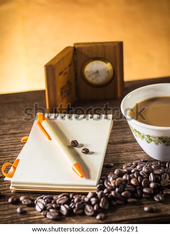 Still life of Pencil on a white spiral squared notebook with cup of coffee