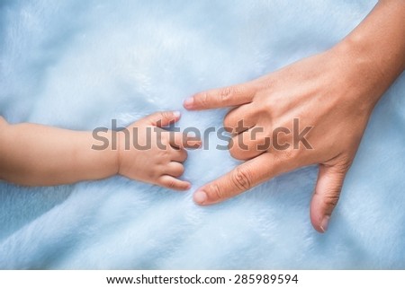 baby and mothers hands made symbol of love.