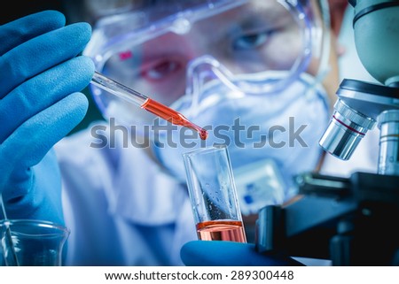 Hands of clinician holding tools during scientific experiment in laboratory