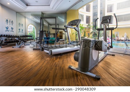 Fitness center with traineger equipments with a view to the pool