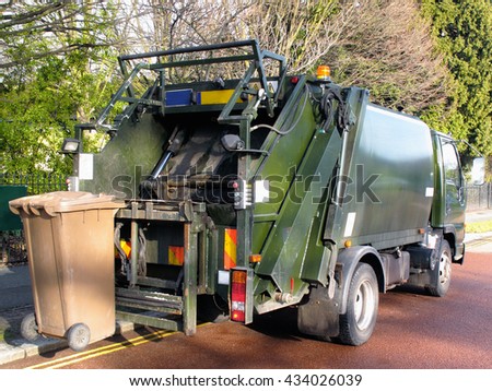 Garbage truck with a bin at the rear