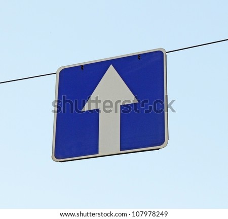 A road sign one-way traffic above the road