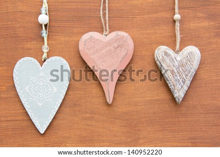 Three Heart Shapes on Wood Background