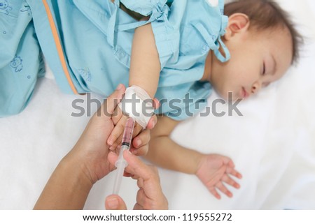 Doctor giving a child an intramuscular injection in arm, shallow