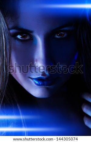 Portrait of nice woman with blue shining lines in studio