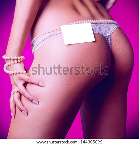 Square photo of female ass in white panties and empty name tag in studio