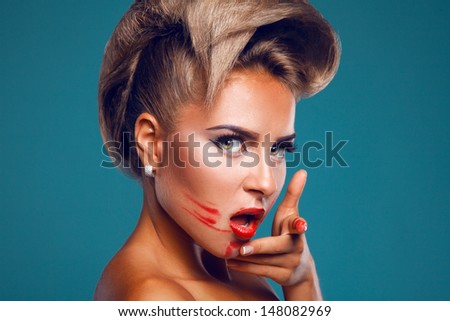 Sensual woman with red lipstick smeared on face