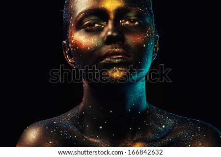 Horizontal portrait of beautiful woman with dark face art in studio