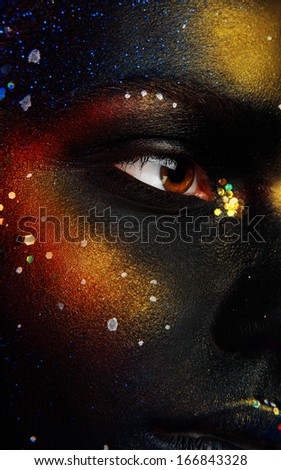 Close up photo of woman eye and dark face art in studio