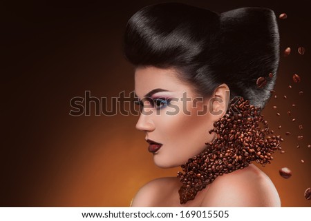 Profile photo of sexy adult woman with professional make up and hairstyle with coffee beans in studio