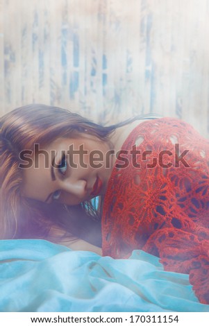Sexy female lying in bed with smoke background in studio