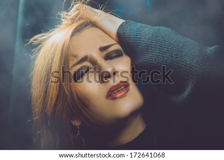 crying woman in studio on black background
