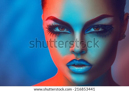 Horizontal portrait of beauty girl with make up in red and blue lights in studio