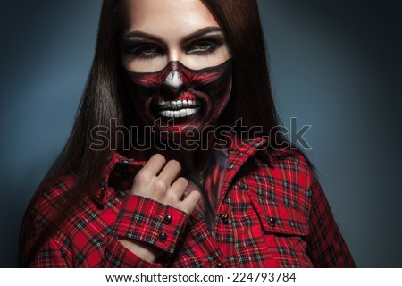 Horizontal portrait of adult girl with scary face art for halloween night in studio