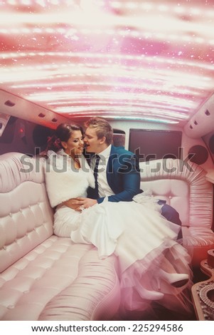 Sexy lovely man and woman just merried driving in limousine kissing