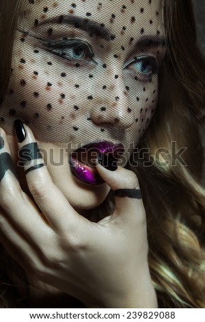 Charming young adult female looking away with lace on face. studio shot