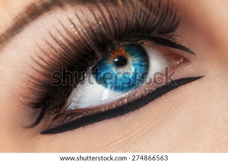 Macro photo of blue eye. Crying woman. Studio shot