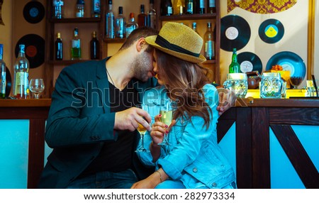 Woman seducing a man in a bar and drinking champagne. horizontal photo