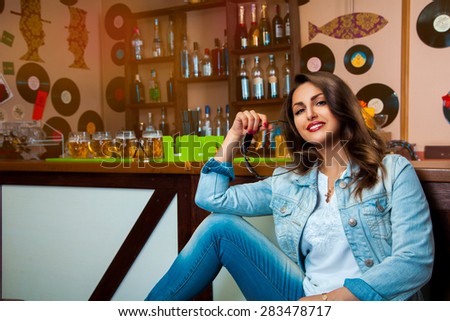 lovely young girl smiling on camera and sit at bar. horizontal photo