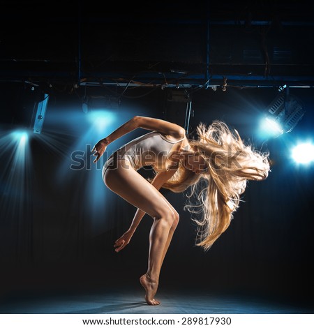 portrait of ballet dancer in pose on stage in theater