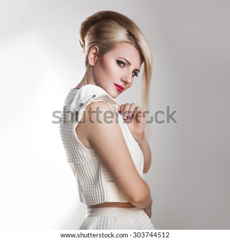square portrait of beautiful adult girl with creative hairstyle. studio shot. gray background.