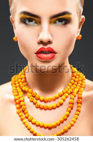 Portrait of beautiful adult girl with rowan on neck and beautiful makeup
