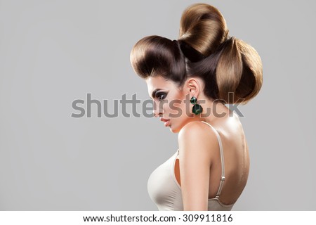Profile portrait of young sexy woman with creative hairstyle and nice makeup in studio