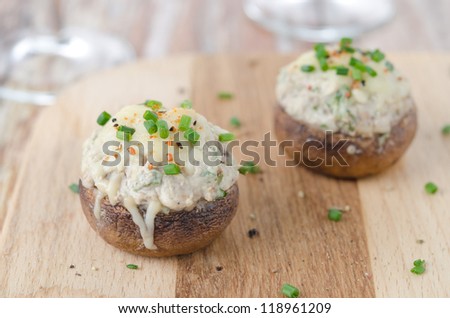 Stuffed mushrooms, baked with cheese and herbs on a wooden board