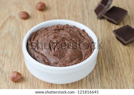 walnut-chocolate paste in a white bowl on a wooden table