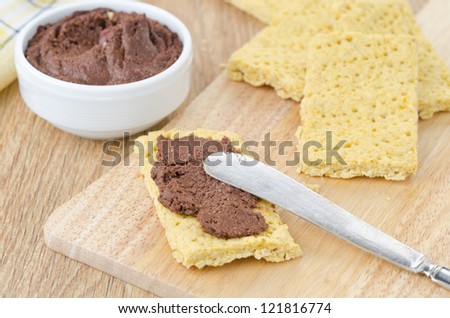 crackers spread with chocolate paste on a wooden board