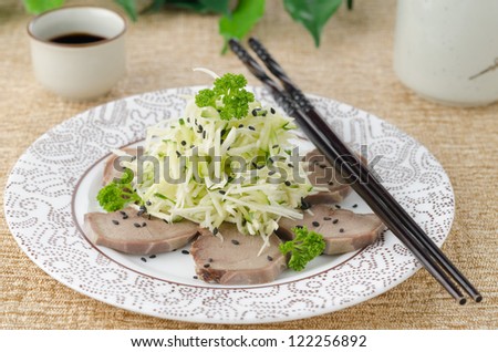 Oriental salad with beef tongue, celery and cucumber on a plate