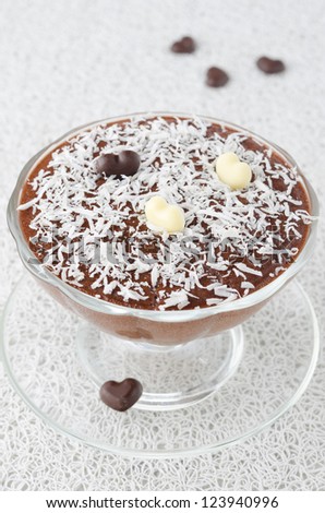 chocolate mousse with chocolate hearts in a glass sundae dish decorated with coconut