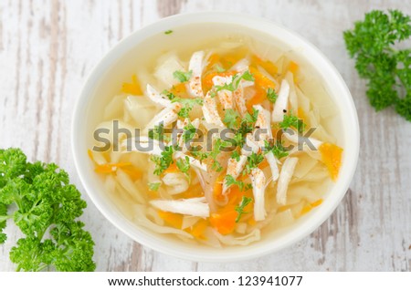 bowl of vegetable soup with chicken and parsley top view