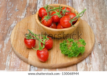 cherry tomatoes in wooden bowl on a wooden board