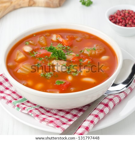roasted tomato soup with beans, celery and sweet pepper garnished with fresh parsley closeup