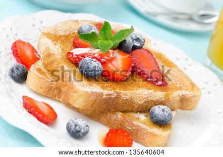 crispy toast with honey, fresh berries, cup of coffee and orange juice for breakfast, close-up