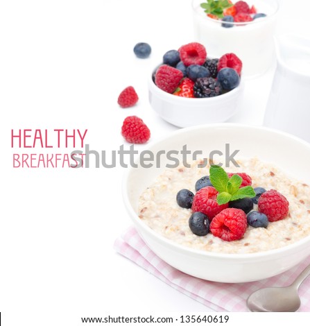 healthy breakfast - oatmeal with fresh berries in a bowl isolated on white, fresh berries and yogurt in the background