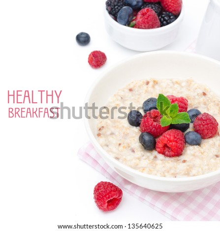 healthy breakfast - oatmeal with fresh berries in a bowl isolated on white, fresh fruit, yogurt, and milk jug in the background, top view