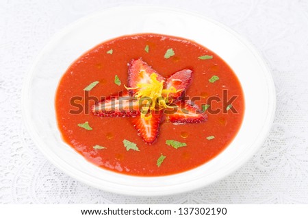 tomato and strawberry gazpacho in a plate, horizontal top view