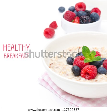 healthy breakfast - oatmeal with fresh berries in a bowl isolated on white, fresh berries in the background