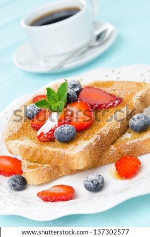 crispy toast with honey, fresh strawberries and blueberries, cup of coffee for breakfast, close-up, vertical