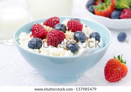 bowl of cottage cheese with berries, honey and nuts, fresh berries and milk for breakfast, horizontal