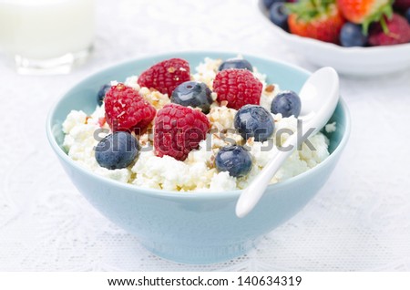 cottage cheese with berries, honey and nuts, fresh berries and milk for breakfast closeup
