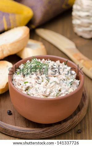 pate of smoked fish with sour cream and greens on a wooden board, vertical