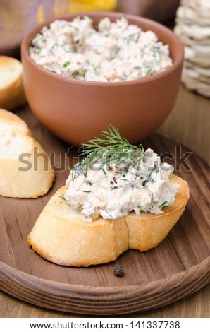 pate of smoked fish with sour cream and dill on toast on a wooden board